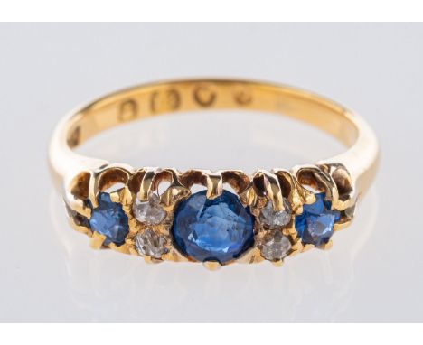 A Victorian 18ct yellow gold ring, claw set with three circular-cut sapphires, interspaced by four old mine-cut diamonds, UK 