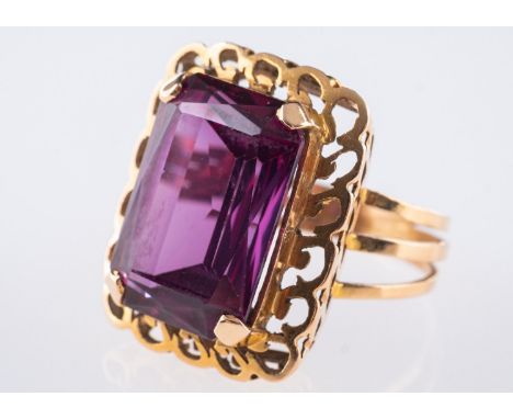 A cocktail style ring, set with a rectangular step-cut synthetic alexandrite, approx. 17.00 carats, in an openwork and collet