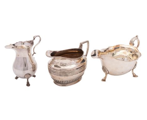 Two silver cream jugs and a sauce boat, the late Victorian oval jug by Henry Stratford, Sheffield 1899, part ribbed and reede