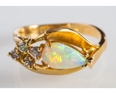 An opal & diamond ring, of foliate design set with a pear-shaped opal cabochon and four brilliant-cut pink diamonds, textured
