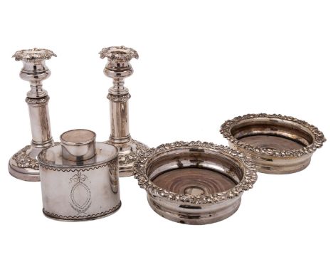 A group of Sheffield plate comprising: a pair of candlesticks, a pair of decanter coasters and a later oval tea caddy in the 