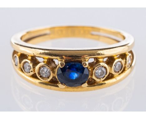 An 18ct yellow gold sapphire & diamond ring, set to the centre with an oval-cut sapphire and set each side with three brillia