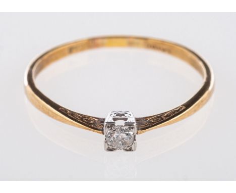 An Art Deco single stone ring, set with an old brilliant-cut diamond, with scroll and geometric style engraving to shoulders 