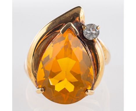A 9ct yellow gold opal ring, set with a pear-shaped fire opal, opal approx. 12.40 carats, with a circular-cut white paste sto