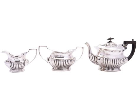 An Edward VII three piece silver tea service by William Adams Ltd, Birmingham 1903, of ogee shaped form, part reeded, with D 