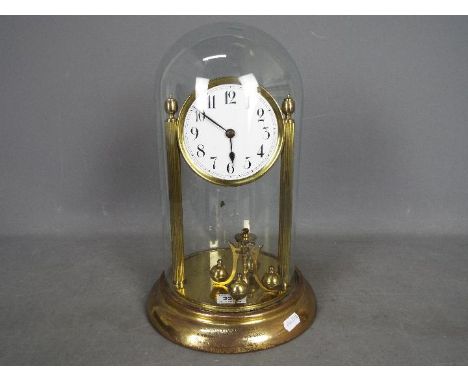 An early 20th century 400-day torsion clock, large 11cm enamel dial, mounted between reeded pillars, unusual pin pallet movem