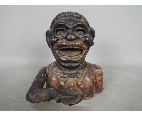 A vintage cast iron mechanical money bank, approximately 15 cm (h).Note: Mechanical cast iron banks were first manufactured i