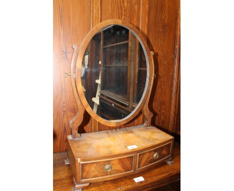 Mahogany swing dressing mirror raised on bowfront platform base upon squat bracket feet, 43cm wide. 