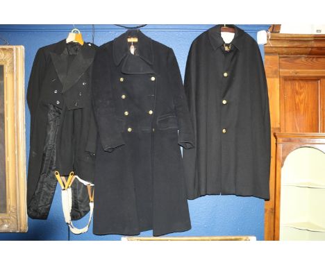 Two British naval overcoats and other uniform.No rank slides are present. Epaulettes are loose in the pocket 