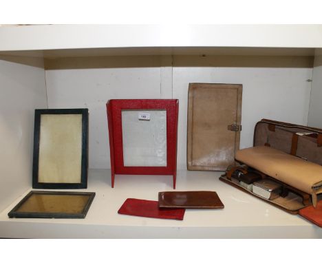 Two grooming sets, cased, a vintage leather satchel, leather framed photograph frames, etc. 