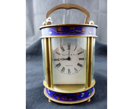 Oval brass Elliot and Son of London carriage clock with curved bevelled edge, glass panels and enamelled decoration