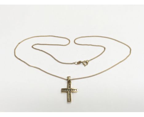 A 9ct gold cross pendant set with diamonds and suspended on a 9ct gold chain, approx 3.6g.