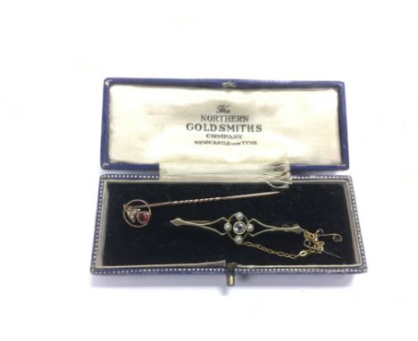 A vintage gold brooch and a tie pin set with stones (2).