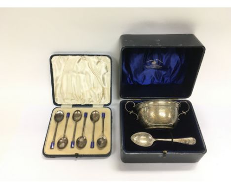A cased silver presentation bowl and spoon together with a cased set of silver and enamel spoons (2).
