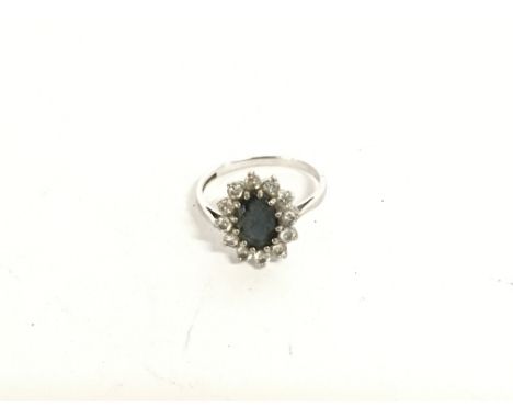 A white gold ring set with a blue sapphire and small diamonds. Size O &amp; 3.60g.