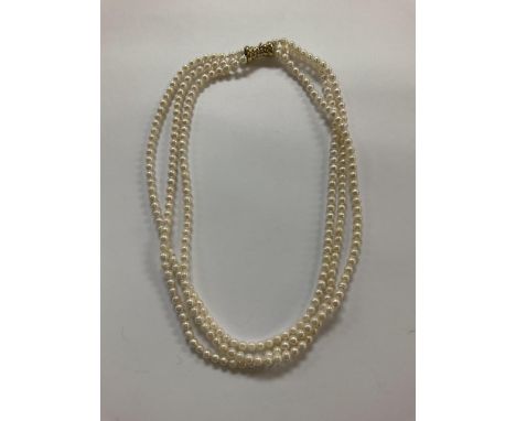 A 3 string seed pearl choker necklace with a 14ct yellow gold clasp.