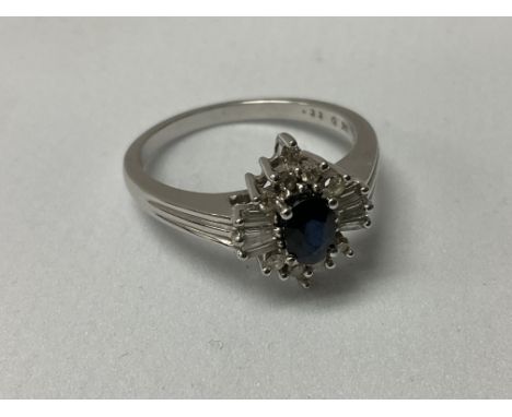 A 9ct white gold central oval cut sapphire surrounded by baguette and brilliant cut stones. R.