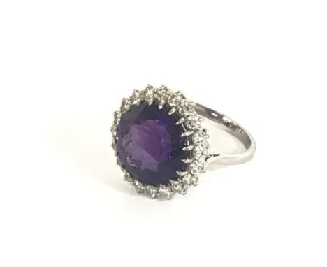 A quality 18 carat white gold ring set with a well cut amethyst and a single row of diamonds possibly G/H colour. Size P. 6.9