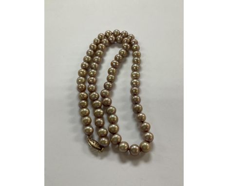 A peach coloured pearl necklace with a 14ct gold clasp.