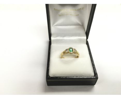 An 18ct gold ring set with an emerald coloured stone and two diamonds, approx 3.4g and approx size J.