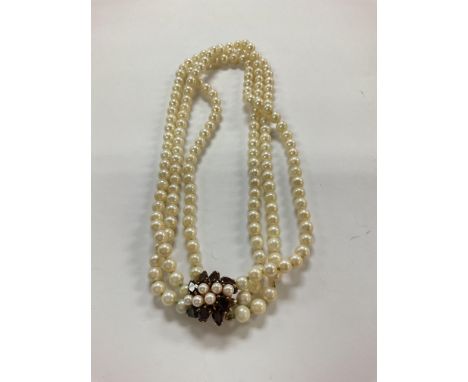 A 3 string pearl choker necklace mounted with a 9ct gold garnet and pearl necklace.