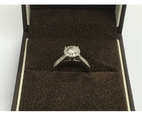 A 9ct white gold ring set with a central diamond, approx 0.5ct, flanked by further diamonds, approx 2.8g and approx size N-O.