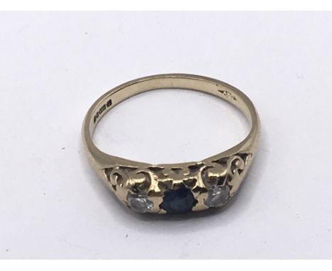 A 9carat gold ring set with a blue sapphire flanked by diamonds. Weight 1.9g ring size K