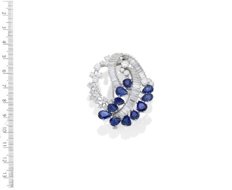 ALDAO: SAPPHIRE AND DIAMOND BROOCH, CIRCA 1960Composed of scrolls of baguette and brilliant-cut diamonds, and pear-shaped sap