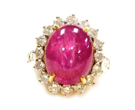 A cabachon ruby and diamond ring, the central high cabachon (highly included) of 13.4mm x 10.1mm, surrounded by sixteen small