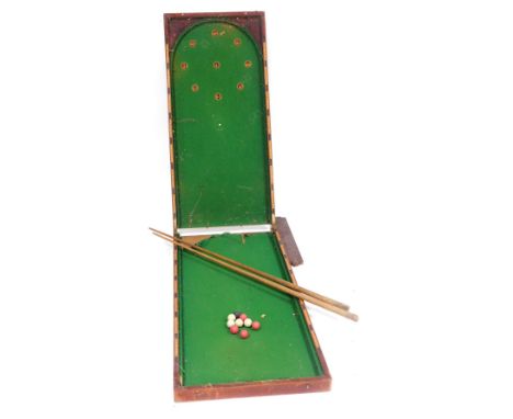 An early 20thC stained mahogany table top bagatelle, with a green baize interior, 123cm high, 115cm wide open, together with 