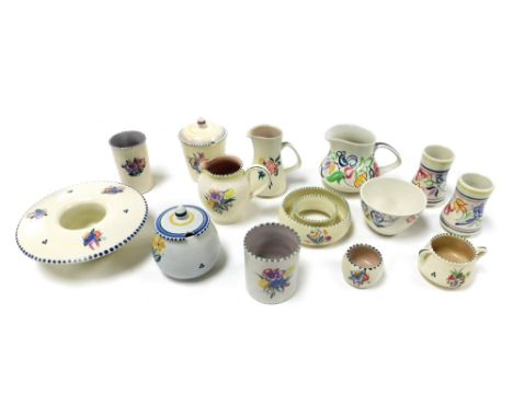 A group of Poole pottery traditionally decorated with flowers, including jugs, preserve pot, small vases and sugar bowls. (a 