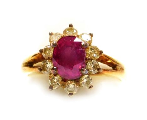 A ruby and diamond set cluster dress ring, the central oval faceted ruby of 6.1mm x 5.2mm surrounded by ten tiny diamonds, se