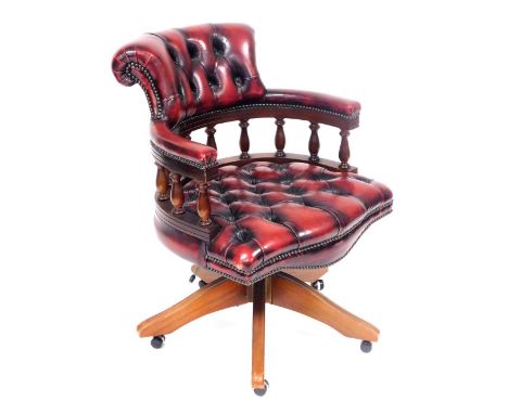 A mahogany and red leather captain's chair, with button back and seat, on castors, 62cm wide. The upholstery in this lot does