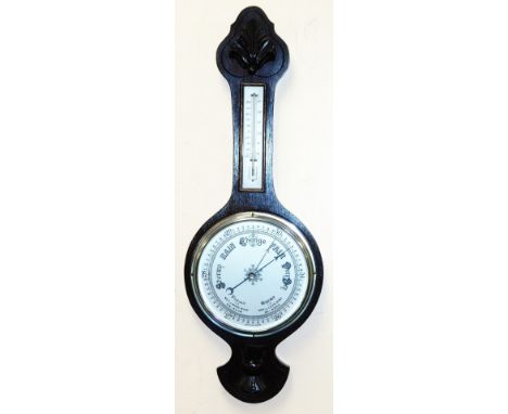 An early 20thC oak cased wheel barometer, with thermometer, the case with foliate carving, 71cm high.