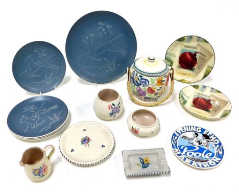 A group of Poole pottery, traditionally decorated with flowers, including a biscuit barrel, ashtray and a teapot stand, toget