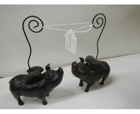 2 ceramic pocket watch stands in the form of flying pigs.