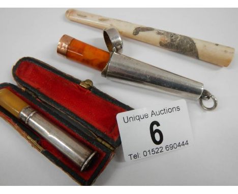 A cased silver cheroot holder with 9ct gold band (a/f), an engraved bone cigarette lighter and another cheroot holder.
