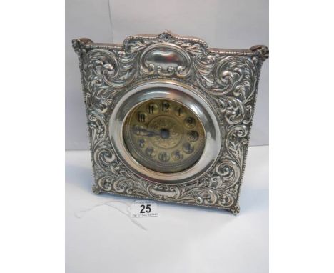 A good quality embossed silver plated mantel clock in good working order (8" wide x 8" high).