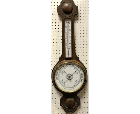 A circa 1900 carved oak cased aneroid barometer with mercury thermometer 79 cm high