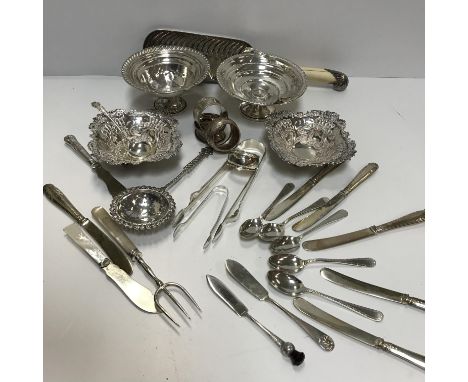 A collection of silver wares to include a pair of early 20th Century silver bonbon dishes with embossed scrolling and ribbon 