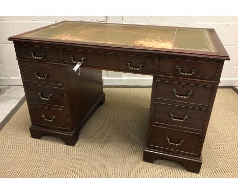 A modern mahogany double pedestal desk in the 19th Century manner, the tooled and gilded leather insert top over three frieze