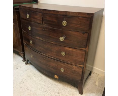 A 19th Century maohgany bow fronted chest, the plain top over two short and three long graduated drawers with brass wreath ha