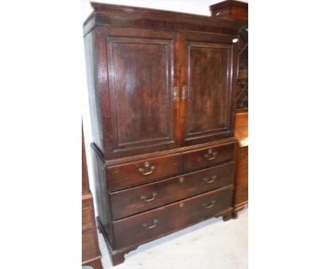 A late 18th Century oak linen press, the moulded cornice over two fielded panel doors enclosing two pine linen shelves with b
