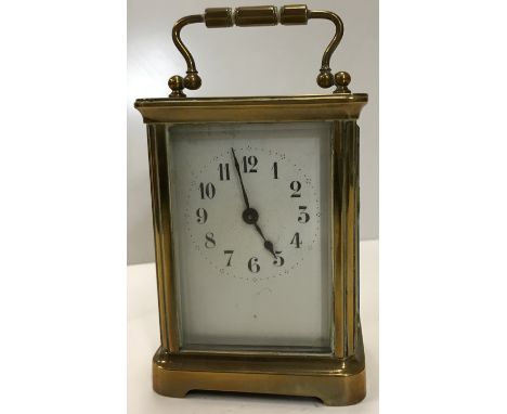 A brass cased carriage timepiece, the enamelled dial with Arabic numerals raised on bracket feet inscribed to top "100 yds Op