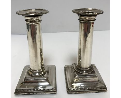 A pair of late 18th Century silver candlesticks of plain column form raised on square tapered base (stamped maker's mark R.I,