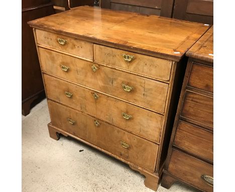 An 18th Century walnut chest, the quartered feather-banded and cross-banded top over two short and three long graduated feath