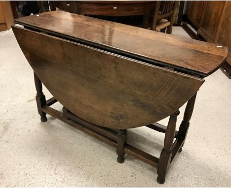 A 19th Century oak oval gate-leg drop-leaf dining table on turned and ringed supports to block feet united by stretchers, 134