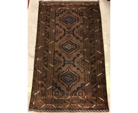 A Caucasian rug, the central panel set with three repeating medallions on a dark blue and brown ground with stylised flower h