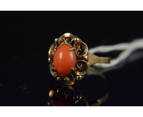 A yellow metal coral set ring, the single cabochon coral with pierced setting, band stamped 585, size K, weight approx 2.3g