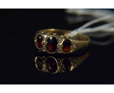 A 9ct gold garnet and diamond set ring, the three oval garnets in rub over setting, interspaced by diamonds (one missing), si